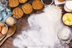 Learn to bake photo of cookies, flour and other ingredients on a wooden bench top