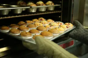 Photo of cookies and cakes being taken out of the oven