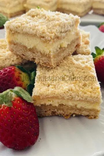 Cheesecake slice squares on white plate with strawberries