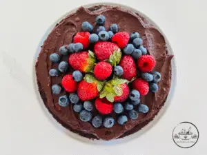 Top view of Cake covered in berries on a white plate