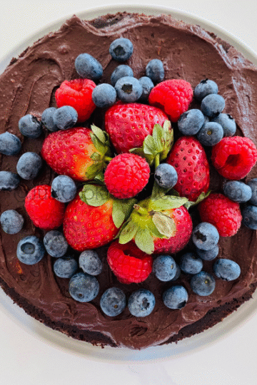 Top view of Cake covered in berries on a white plate